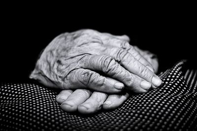 Close-up of woman hand over black background