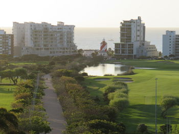 Buildings by sea against clear sky