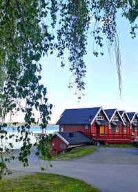 Houses by trees against sky