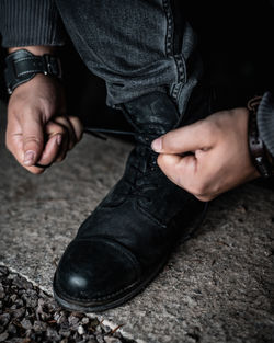 Low section of man tying shoelace