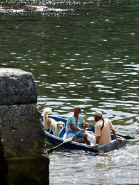 Men sitting on boat in lake