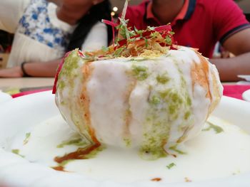 Close-up of hand holding ice cream in plate