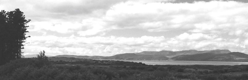 Scenic view of mountain range against cloudy sky