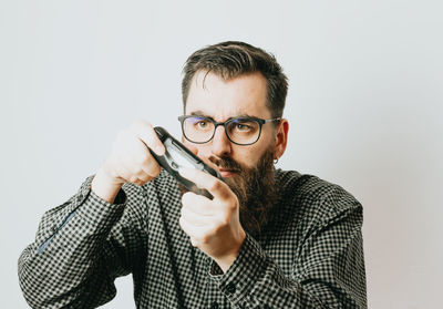 Young man using mobile phone against white background