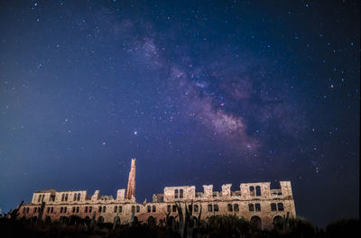 Low angle view of buildings against sky at night