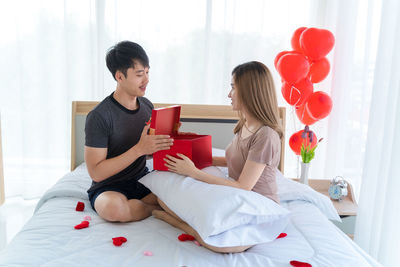 Women sitting on red balloons