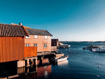 Houses by sea against blue sky