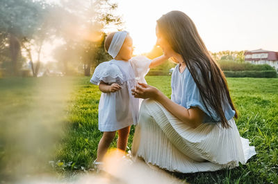 Rear view of young woman standing on field