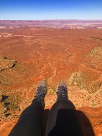 Low section of person on land against sky