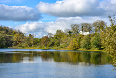 Scenic view of lake by trees against sky