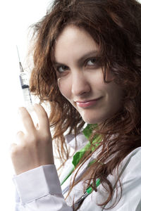 Portrait of beautiful woman holding face against white background