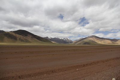 Beautiful mountains and red plateau meadows under the blue sky and white clouds