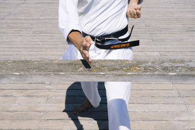 Senior karate master practices combat techniques on the wooden board