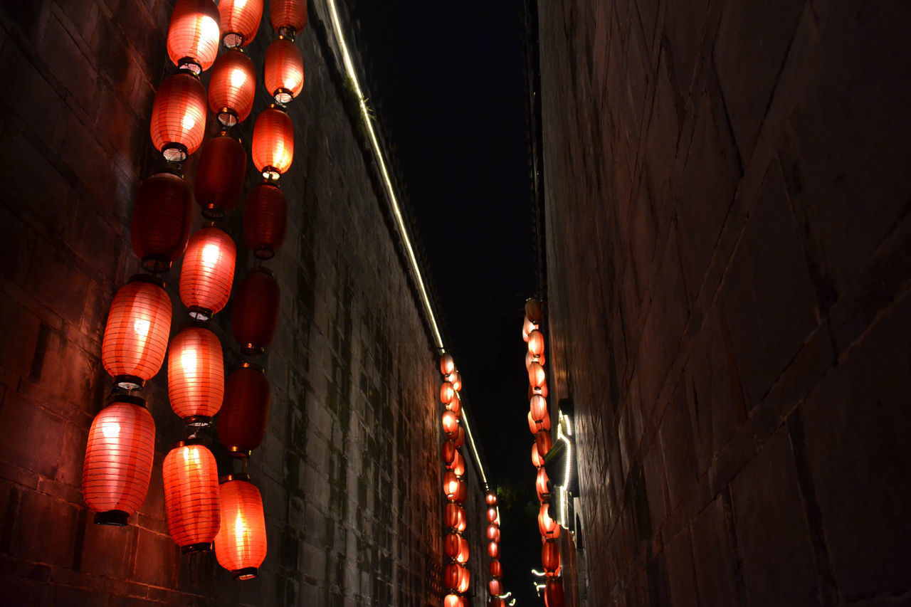 LOW ANGLE VIEW OF ILLUMINATED LANTERNS HANGING FROM CEILING