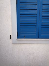 Closed window on white wall of building