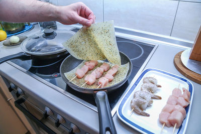 Midsection of person having food in kitchen