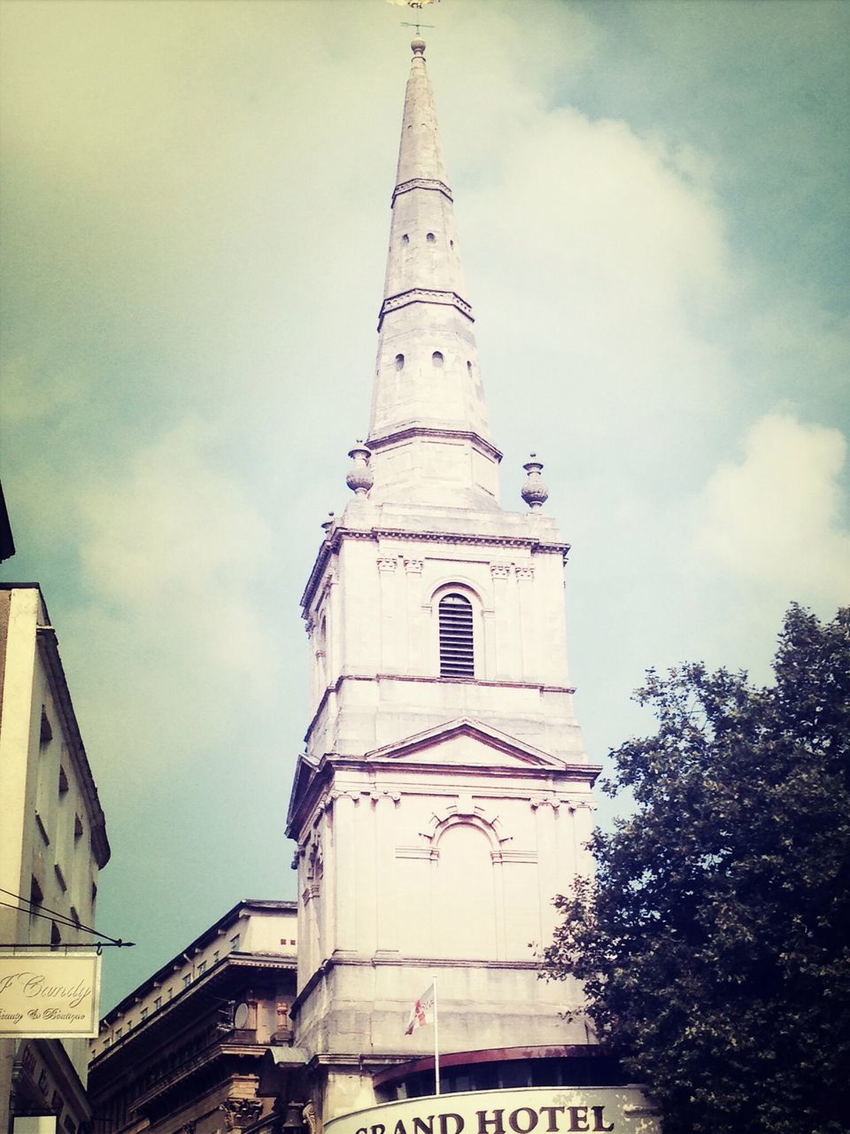 architecture, building exterior, built structure, low angle view, sky, church, cloud - sky, tower, religion, place of worship, cloud, clock tower, spirituality, city, building, day, outdoors, cloudy