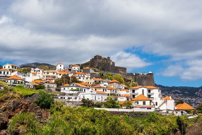 Buildings in town against sky