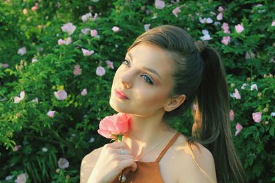 Portrait of beautiful woman with red flower