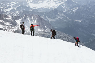 People walking on snowcapped mountain
