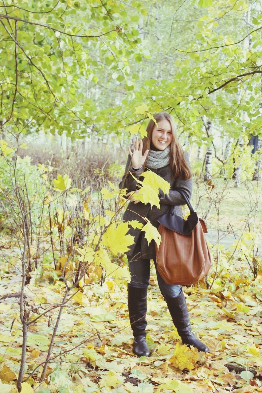 lifestyles, casual clothing, full length, young adult, person, leisure activity, tree, standing, young women, portrait, looking at camera, forest, front view, growth, smiling, three quarter length, nature