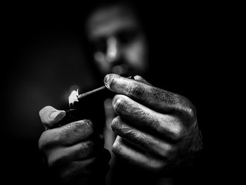 Close-up of a young man igniting cigarette