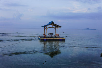 Lifeguard hut in sea against sky