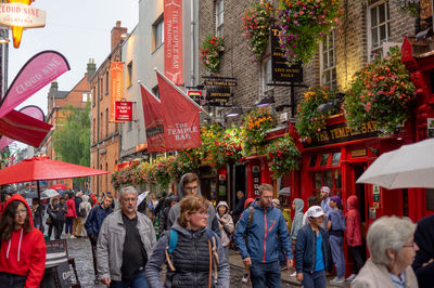 People walking on street against buildings in city