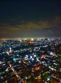 High angle view of illuminated city against sky at night