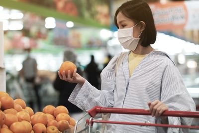 Full length of woman holding fruits at market