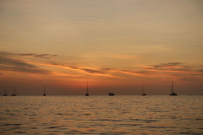 Boats on sea against sky during sunset