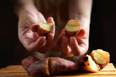 Close-up of person holding apple on table