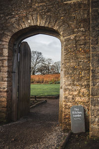 Trees on field seen through wall