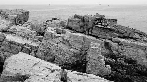 Rocks by sea against sky