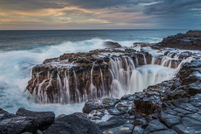 Scenic view of waterfall against sky