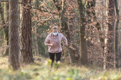 Man standing amidst trees in forest