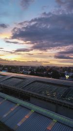 High angle view of illuminated cityscape against cloudy sky