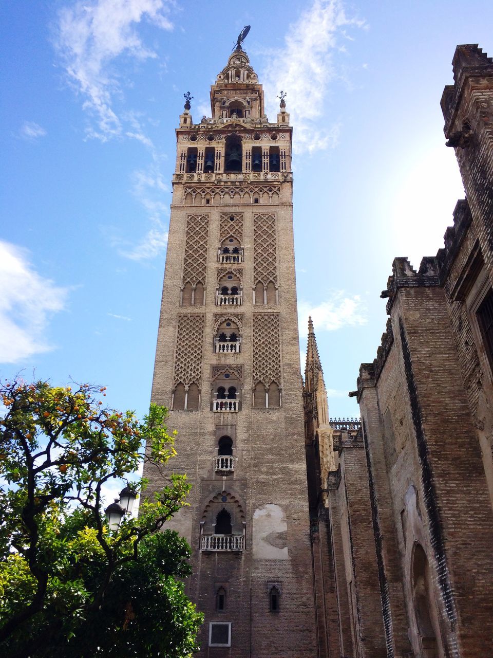 architecture, building exterior, built structure, religion, church, low angle view, place of worship, spirituality, sky, clock tower, tower, cathedral, tree, history, cross, tall - high, cloud - sky, cloud