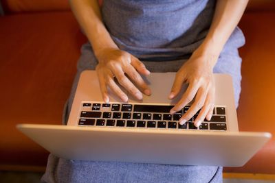 Midsection of woman using mobile phone at home