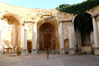 Rear view of woman visiting temple against building