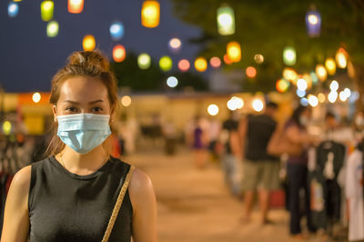 Young women wear medical protection mask in night market
