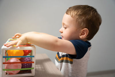 A cute toddler boy is playing a game with sensory colorful balls. sensory and tactile activities.