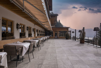 Elegant outdoor dining area at luxurious ski resort against sky during sunset