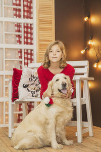 Portrait of young woman with dog at home