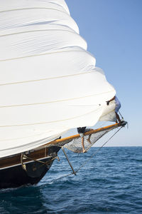 Sailboat sailing on sea against clear sky