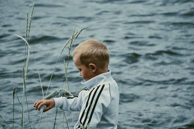 Rear view of boy standing in sea