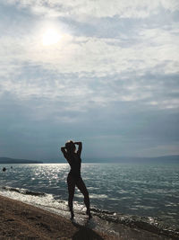 Full length of man standing on beach against sky