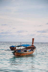 Boat moored in sea against sky