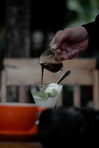 Midsection of person pouring wine in glass