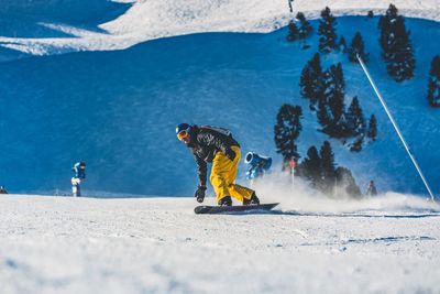 Man snowboarding on snow covered field